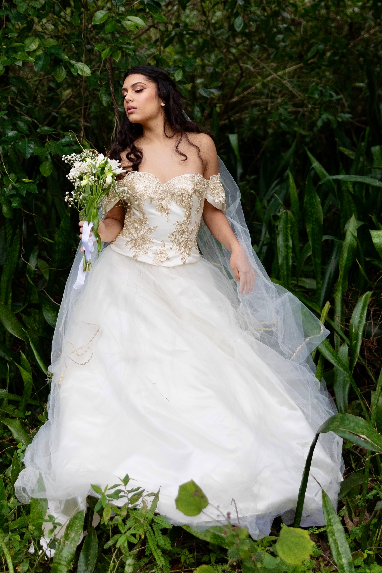 Bride in a white wedding dress with floral details, design by Alexas